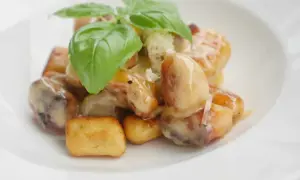 Gylla, gyllene gnocchi i krämig sås, toppad med färsk basilika. En härlig rätt att steka gnocchi i.