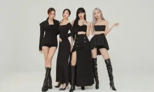 Cztery członkowie BLACKPINK w czarnych, stylowych strojach pozują do zdjęcia.