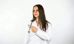Lekarka w białym kitlu wskazuje palcem, sugerując, że warto rozważyć Locoid Lipocream na problemy skórne.
