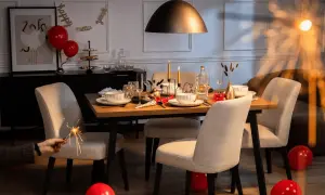 Stół nakryty do kolacji z balonami, świecami i zimnymi ogniami.