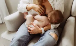 En mamma ammar sitt barn. Diskussioner om alkohol och amning är viktiga för att säkerställa barnets välmående.