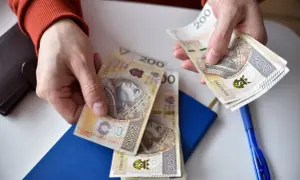Ręce liczą banknoty 200 zł. Może to być wypłata, oszczędności, albo nawet renta alkoholowa, którą ktoś chce przeznaczyć na coś innego.