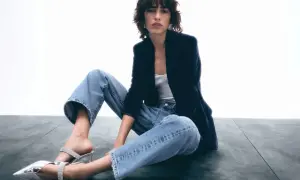 Frau in lässigen Jeans, Samtblazer und glitzernden Mules. Ein Look, der casual chic perfekt verkörpert.