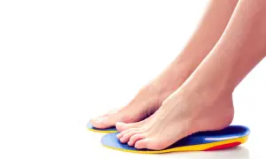 Piedi femminili appoggiati su ortesi per piede colorate, per un comfort e supporto ottimali.