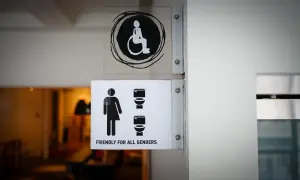 Znaki informujące o dostępności pomieszczeń higieniczno-sanitarnych, wymagania bhp. Widoczny symbol osoby na wózku inwalidzkim i toalety dla wszystkich płci.