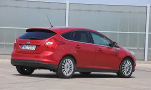 Czerwony Ford Focus MK3 kombi, gotowy do wymiany żarówki stopu.