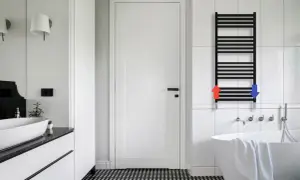 Nowoczesna łazienka z czarną drabinką, ilustrującą jak podłączenie grzejnika łazienkowego do starej instalacji może być proste.