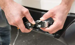Mains de personne effectuant le branchement prise caravane. Connexion d'un connecteur électrique à une prise sur un véhicule.