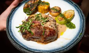 En saftig biff med pepparsås, grillad zucchini, majskolv och lök. Ett perfekt pepparsås recept för en lyxig middag.