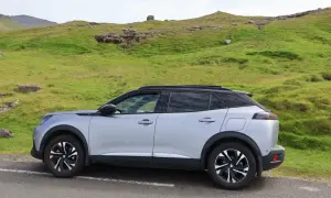 Silver Peugeot 2008 parkerad vid en grön sluttning, kanske med ett litet problem.