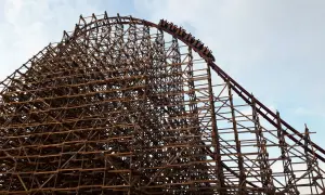 Drewniana konstrukcja rollercoastera w Energylandii, z wagonikami wjeżdżającymi na szczyt. Czy Energylandia jest otwarta w deszcz?