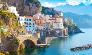 Widok na wybrzeże Amalfi z kolorowymi domami na klifie i mostem. Nawet przy takich widokach, objawy lęku przed ekspozycją na szlakach wybrzeża Amalfi a wyspa Capri mogą być odczuwalne.