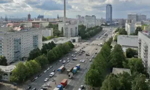 Blick über die Stalinallee in Berlin mit ihren charakteristischen Plattenbauten und viel Verkehr.