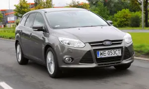 Szary Ford Focus MK3 1.6 TDCI w wersji kombi jedzie po drodze.