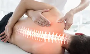 Hände eines Therapeuten behandeln den Rücken eines Mannes. Die Wirbelsäule ist hervorgehoben. Ein visueller Hinweis auf den Unterschied zwischen Osteopathie und Chiropraktiker.