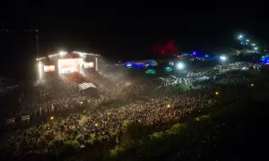 Tłum ludzi na koncercie festiwalu Audioriver, światła sceny i ekranów tworzą magiczną atmosferę nocnego wydarzenia.