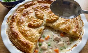 En gyllene kycklingpaj med krämig fyllning av kyckling, morötter och ärtor. Perfekt för ett mysigt kycklingpaj recept.