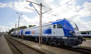 Nowe lokomotywy PKP Intercity, gotowe do podróży z Lublina. Zielona góra w tle, chmury na niebie.