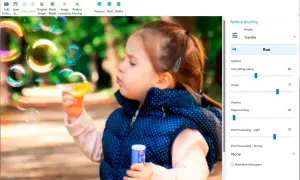 Dziewczynka dmucha bańki. Program Easy Photo Unblur pomaga jak wyostrzyć zdjęcie, oferując opcje redukcji rozmycia i poprawy detali.