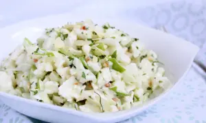 Ein **schneller Kohlrabisalat** mit Apfelstücken, Mandelsplittern und Petersilie in einer weißen Schüssel.