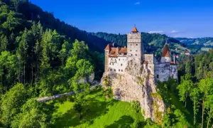 Zamek Bran, jedna z głównych rumuńskich atrakcji, majestatycznie wznosi się na skale pośród zielonych wzgórz i lasów.