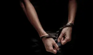 Mains menottées dans l'obscurité, symbolisant un vol, crime ou délit. La justice a rattrapé le coupable.