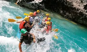 Un gruppo si diverte con il rafting nelle Marche, pagaiando tra spruzzi d'acqua cristallina e rocce imponenti. Un'avventura emozionante!