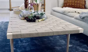 Ett unikt diy soffbord med flätad topp och träben. Prydnader som en guldfärgad myra och en liten vas ger liv åt bordet.
