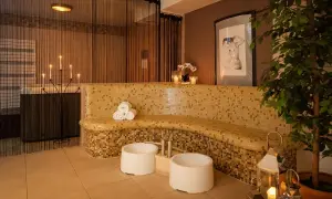 Relaks w spa: mozaikowa ławka, świece, wanna i rośliny tworzą atmosferę spokoju.