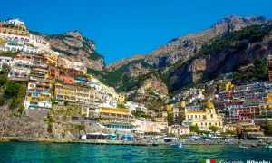 Positano, jedno z najpiękniejszych miejsc we Włoszech, z kolorowymi domami wciśniętymi w zbocze góry nad turkusowym morzem.