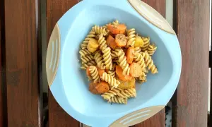 Zdrowy i kolorowy posiłek dla niemowlaka: makaron fusilli z marchewką i ziemniakami, doprawiony ziołami.