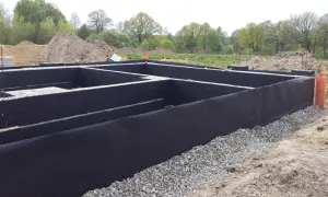 Fundamenty domu zabezpieczone czarną membraną i żwirem. To kluczowy etap, by wiedzieć, czym smarować fundamenty, by chronić je przed wilgocią.