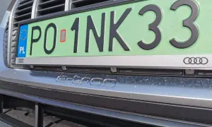 Zielone tablice rejestracyjne z napisem "e-tron" na zderzaku Audi.