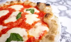 Pyszna pizza margherita z rozpływającym się serem mozzarella, sosem pomidorowym i świeżą bazylią na chrupiącym cieście.