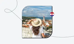 Kobieta w kapeluszu podziwia widok na chorwackie miasto. Chorwacja w strefie Schengen to marzenie wielu podróżników.