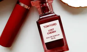 Elegancka butelka perfum Tom Ford Lost Cherry 50 ml w odcieniu głębokiej czerwieni, obok czerwonego opakowania.