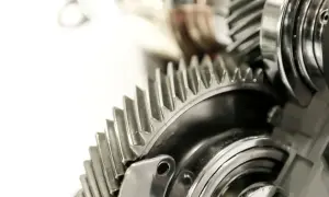 Metalowe koła zębate, część skomplikowanej przekładni ciernej, lśnią w zbliżeniu.