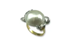 Anillo de oro con un gran anillo perla japonesa central, rodeado de pequeños diamantes incrustados en filigrana de plata.