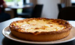 Une tarte au fromage dorée et appétissante, prête à être dégustée dans une ambiance chaleureuse.