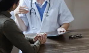 Pacjentka rozmawia z lekarzem, który korzysta z tabletu. Czy lekarz POZ widzi prywatne wizyty?