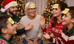 Familia riendo y jugando a juegos interactivos de Navidad con notas en la frente. ¡Pura diversión navideña!