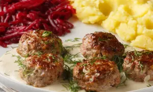 Soczyste klopsy w sosie z koperkiem, podane z purée ziemniaczanym i buraczkami.