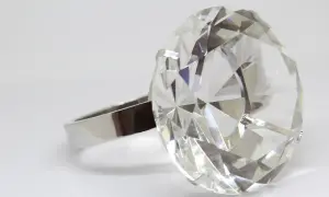 Duży, fasetowany kryształ w kształcie diamentu na srebrnym pierścionku.