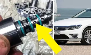 En mekaniker undersöker en del från en dubbeltrapp koppling, troligen relaterad till en vit Volkswagen vid havet.
