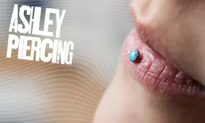 Ashley piercing na ustach z opalizującym kamieniem.