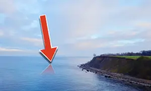 Roter Pfeil zeigt auf die Ostsee, wo sich Meerforellen-Hotspots befinden. Küste mit Steilküppe im Hintergrund.