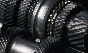 Zbliżenie na metalowe koła zębate i wałki, element skomplikowanej manualnej skrzyni biegów.