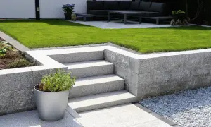 Moderne Gartenmauer aus Granit mit Stufen und Sitzbereich. Tolle Ideen für Gartenmauern, die Struktur und Eleganz verleihen.