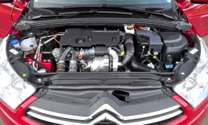 Silnik w czerwonym Citroen C4 2008. Widok komory silnika z turbosprężarką i przewodami.