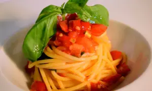 Spaghetti al pomodoro fresco, conditi con pomodoro fresco a cubetti e basilico profumato, un classico intramontabile.